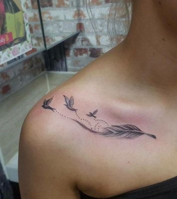 Tatouage plume sur l'épaule avec trois oiseaux